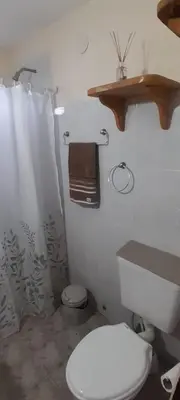 a bathroom with a toilet and a shower curtain at Cabañas de Ensueño in Cuesta Blanca