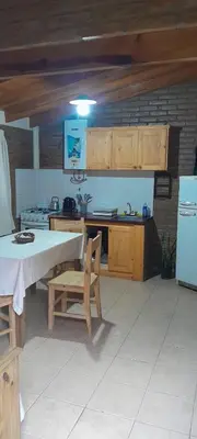 a kitchen with a table and a stove and a refrigerator at Cabañas de Ensueño in Cuesta Blanca