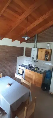 a kitchen with a table and a stove top oven at Cabañas de Ensueño in Cuesta Blanca