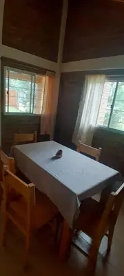a dining room table with two chairs and a white tablecloth at Cabañas de Ensueño in Cuesta Blanca