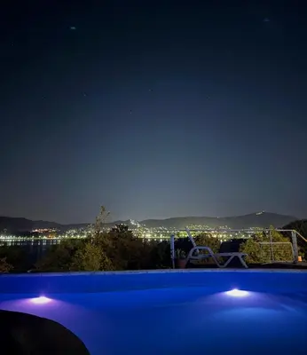 a nightime view of a city from a swimming pool at Casa con hermosa vista al lago in Villa Carlos Paz