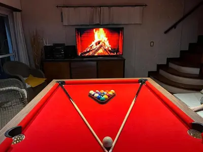 a pool table with balls in front of a fireplace at Casa con hermosa vista al lago in Villa Carlos Paz