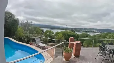 a balcony with a swimming pool and a view of a river at Casa con hermosa vista al lago in Villa Carlos Paz