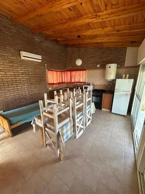 a kitchen with a table and chairs and a refrigerator at Cabaña La Estancia in Villa Carlos Paz