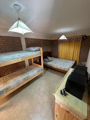 a room with two bunk beds and a table at Cabaña La Estancia in Villa Carlos Paz