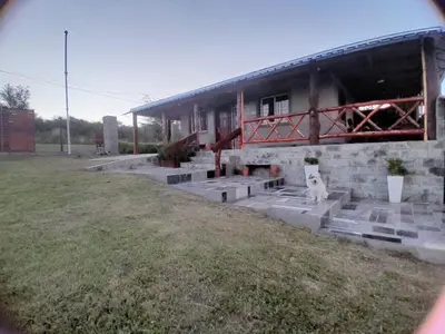 a dog sitting in front of a building at Mi sueño en la naturaleza in Potrero de Garay