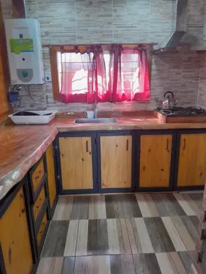 a kitchen with wooden cabinets and a sink at Mi sueño en la naturaleza in Potrero de Garay