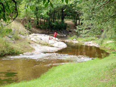 a person and a dog crossing a river at Mi sueño en la naturaleza in Potrero de Garay