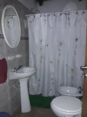 a bathroom with a sink and a toilet and a mirror at Cabaña La Pasionaria in Villa Quillinzo