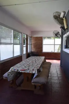 a room with a table and a couch and windows at Casa Santa Lucía in Bialet Massé
