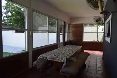 a room with a table and a couch and windows at Casa Santa Lucía in Bialet Massé