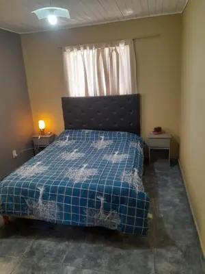 a bedroom with a bed with a blue comforter and a window at La Loma in Villa del Dique