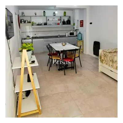 a dining room and kitchen with a table and chairs at Brisas Departamento Boutique in Villa Carlos Paz