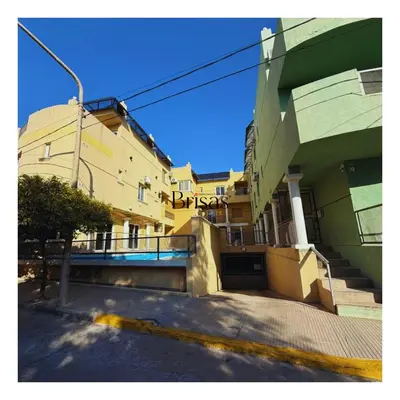 a building on a street next to a building with stairs at Brisas Departamento Boutique in Villa Carlos Paz