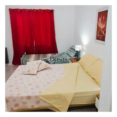 a bed in a room with a red curtain at Brisas Departamento Boutique in Villa Carlos Paz