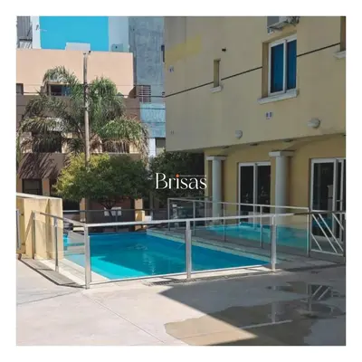 a swimming pool in front of a building at Brisas Departamento Boutique in Villa Carlos Paz