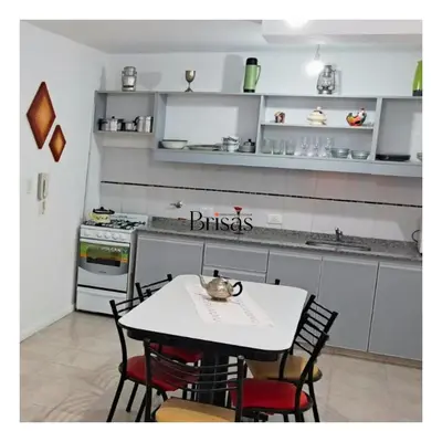 a kitchen with a white table and chairs and a counter at Brisas Departamento Boutique in Villa Carlos Paz