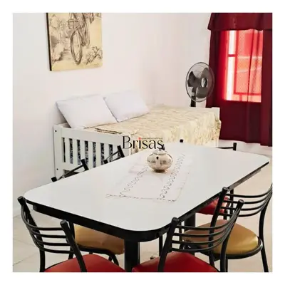 a white table with chairs and a bed in a room at Brisas Departamento Boutique in Villa Carlos Paz