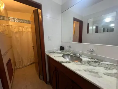 a bathroom with a sink and a large mirror at Casa Edison in Villa Carlos Paz