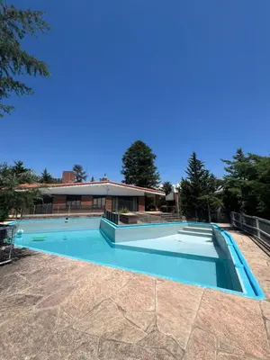 a swimming pool in front of a house at Casa Edison in Villa Carlos Paz