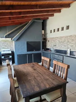 a large kitchen with a wooden table and chairs at La Bernardina in Villa Carlos Paz