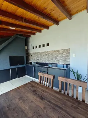 a kitchen with two wooden benches in a room at La Bernardina in Villa Carlos Paz