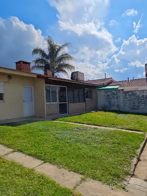 a house with a palm tree in the yard at La Bernardina in Villa Carlos Paz