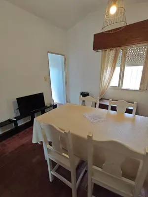 a dining room with a white table and chairs at La Bernardina in Villa Carlos Paz