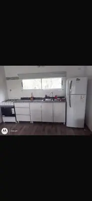 a kitchen with a white refrigerator and a window at La casita de Clau in Los Molles