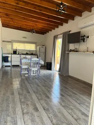 a living room with a table and a kitchen at La casita de Clau in Los Molles