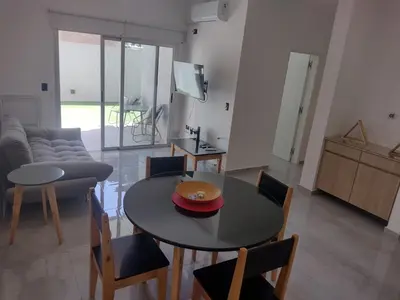 a living room with a table and chairs and a couch at Departamento céntrico a cuadras del lago san roque in Villa Carlos Paz