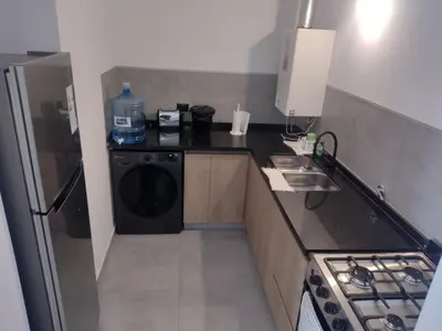 a small kitchen with a washer and dryer at Departamento céntrico a cuadras del lago san roque in Villa Carlos Paz