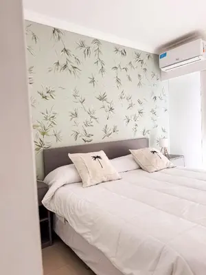 a bedroom with a large white bed with flowers on the wall at Apart France - Dos Dormitorios - Cochera, gim, piscina y spa in Río Cuarto