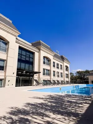a building with a swimming pool in front of it at Apart France - Dos Dormitorios - Cochera, gim, piscina y spa in Río Cuarto