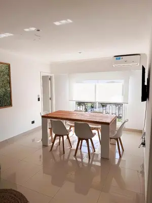a dining room with a wooden table and chairs at Apart France - Dos Dormitorios - Cochera, gim, piscina y spa in Río Cuarto