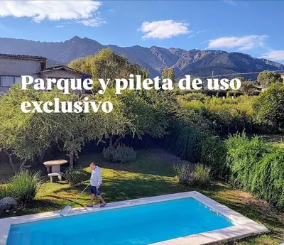 a man is standing next to a swimming pool at Casa Salvia in Los Hornillos