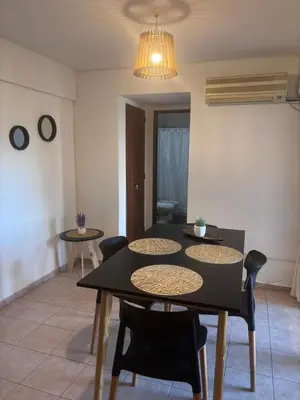 a dining room with a black table and chairs at Departamento Artigas in Cordoba
