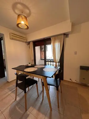 a dining room table with chairs and a chandelier at Departamento Artigas in Cordoba