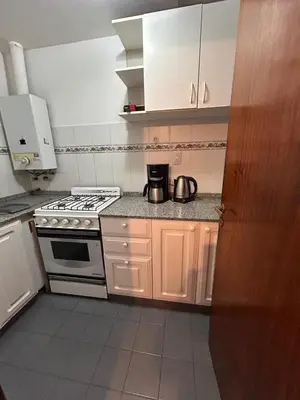 a kitchen with white cabinets and a stove at Departamento Artigas in Cordoba