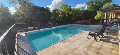 a swimming pool with two chairs next to it at Tiny House Playa Mansa in Mina Clavero