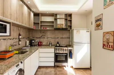 a kitchen with a white refrigerator and a stove at Cabañas Imagina in Villa General Belgrano