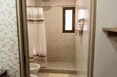 a bathroom with a shower curtain and a toilet at Cabañas Imagina in Villa General Belgrano