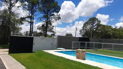 a swimming pool in a yard next to a fence at Casa con pileta in Río Cuarto