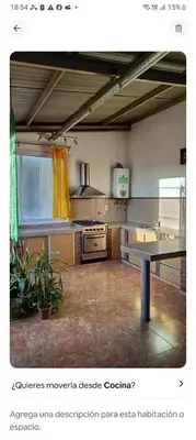 a large kitchen with a table in the middle at Depto amoblado in Río Tercero