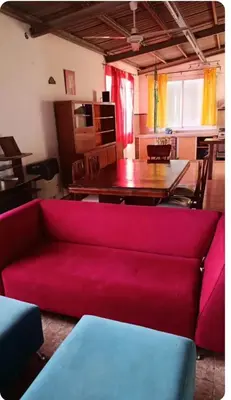 a living room with a red couch and a table at Depto amoblado in Río Tercero