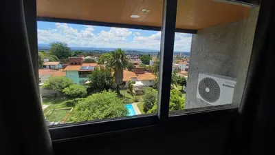 a window with a view of a city and a pool at Carcano Temporarios in Villa Carlos Paz