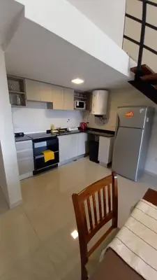 a kitchen with a refrigerator and a chair in it at Carcano Temporarios in Villa Carlos Paz
