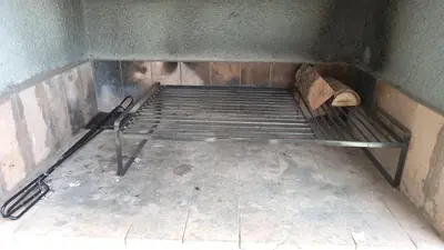 a metal bed in a corner of a room at Carcano Temporarios in Villa Carlos Paz