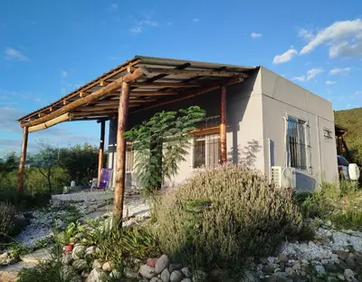 a small house with a wooden pergola at Entre Tanto in Luyaba