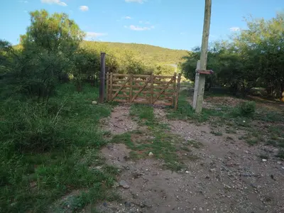 a wooden fence in the middle of a field at Entre Tanto in Luyaba